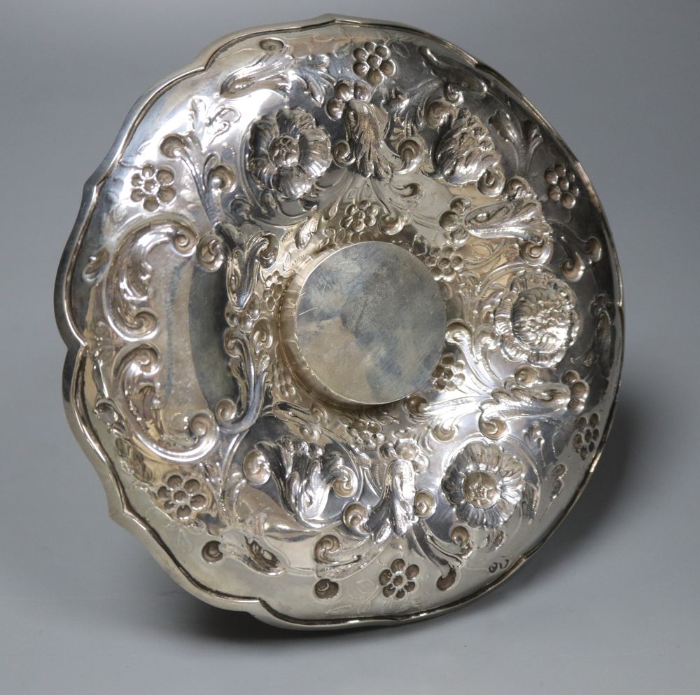 A late Victorian repousse silver mounted glass inkwell, on a repousse silver stand, London, 1891, height 14.4cm.